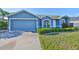 Inviting single-story home with a well-maintained lawn and attached two-car garage at 10540 Carloway Hills Dr, Wimauma, FL 33598