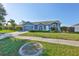 Inviting single-story home with blue exterior, two-car garage, and established landscaping at 10540 Carloway Hills Dr, Wimauma, FL 33598