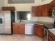 View of the kitchen showcasing stainless steel appliances and wood cabinets at 10540 Carloway Hills Dr, Wimauma, FL 33598