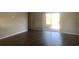 Bright open-concept living room featuring sleek flooring and sliding glass door to backyard at 10540 Carloway Hills Dr, Wimauma, FL 33598