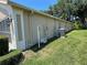 Side exterior of home with grass, trees, utilities and screened in lanai at 11185 Heathrow Ave, Spring Hill, FL 34609