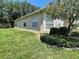 Side exterior view of home showcasing manicured lawn and shrubbery at 11185 Heathrow Ave, Spring Hill, FL 34609