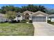 Inviting single-story home with a well-manicured lawn, screened garage, and charming curb appeal at 11185 Heathrow Ave, Spring Hill, FL 34609