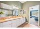 A large primary bathroom with dual sinks, a big mirror, and an open doorway to the main bedroom at 11519 Cypress Reserve Dr, Tampa, FL 33626