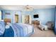 Spacious main bedroom with blue accents, a seating area, and a TV at 11519 Cypress Reserve Dr, Tampa, FL 33626