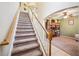 Carpeted staircase with white railing and wood banister leading to the second floor at 11519 Cypress Reserve Dr, Tampa, FL 33626