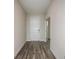 Hallway with wood-look flooring leading to a bright white front door and another doorway at 12170 Cattleside Dr, Riverview, FL 33579