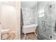 Luxurious bathroom featuring a clawfoot tub, marble wall, and glass-enclosed shower at 12408 Wexford Hills Rd, Riverview, FL 33569