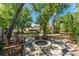 Charming backyard featuring a stone fire pit surrounded by mature trees and comfortable seating at 12408 Wexford Hills Rd, Riverview, FL 33569