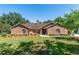 Charming brick home featuring a well-manicured lawn, complemented by mature trees and lush landscaping at 12408 Wexford Hills Rd, Riverview, FL 33569