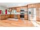 Updated kitchen with stainless steel appliances, wooden cabinets, and tiled backsplash, perfect for culinary enthusiasts at 12408 Wexford Hills Rd, Riverview, FL 33569