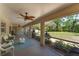 Relaxing screened patio with stylish wicker furniture and a peaceful view of the manicured backyard at 12408 Wexford Hills Rd, Riverview, FL 33569