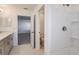 Bright bathroom featuring double vanity, tiled floors, and a glass-enclosed shower at 12414 Gust Ct, Hudson, FL 34669