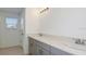 Bathroom with double vanity, gray cabinets, and modern lighting at 12414 Gust Ct, Hudson, FL 34669