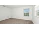 Carpeted bedroom with light walls and a window at 12414 Gust Ct, Hudson, FL 34669