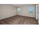 This bedroom features neutral walls, carpet, and two windows allowing for ample natural light at 13034 Wellspring Dr, Lithia, FL 33547