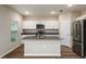 Bright kitchen featuring an island, stainless steel appliances, stone countertops, and white cabinetry at 13034 Wellspring Dr, Lithia, FL 33547