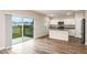Open kitchen with white cabinets, island, stainless steel appliances, and sliding glass doors to a backyard at 13034 Wellspring Dr, Lithia, FL 33547