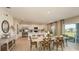 Open-concept dining area with modern table setting, leading to a bright kitchen with stainless appliances at 13470 Tropical Breeze Way, Hudson, FL 34669