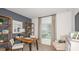 Well-lit home office with a modern desk, shelving, and comfortable seating at 13470 Tropical Breeze Way, Hudson, FL 34669