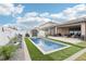 Backyard oasis with an in-ground pool, manicured landscaping, and pool-side seating at 14227 Alistar Manor Dr, Wimauma, FL 33598