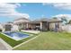 Well-maintained backyard with in-ground pool, covered patio, and green lawn at 14227 Alistar Manor Dr, Wimauma, FL 33598