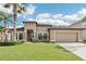 Beautifully landscaped single-Gathering home with palm trees and a two-car garage at 14227 Alistar Manor Dr, Wimauma, FL 33598
