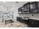 Modern kitchen with dark cabinets, stainless steel appliances, granite counters, and gray subway tile backsplash at 14227 Alistar Manor Dr, Wimauma, FL 33598