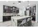 Bright kitchen with dark cabinets, stainless steel appliances, granite countertops, and breakfast bar seating at 14227 Alistar Manor Dr, Wimauma, FL 33598
