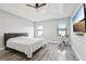 Bright primary bedroom with tray ceilings, fan, two windows and exercise equipment at 14227 Alistar Manor Dr, Wimauma, FL 33598