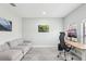 Bright office space with gray plank flooring, comfortable couch, natural light, and desk set for productivity at 14227 Alistar Manor Dr, Wimauma, FL 33598