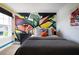 Modern bedroom with a graffiti-style accent wall and stylish decor, creating a unique space at 14423 Meadow Bird Ave, Riverview, FL 33579