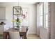 Bright dining room with modern lighting, neutral decor, large modern art piece, and large windows at 14423 Meadow Bird Ave, Riverview, FL 33579