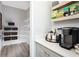 Walk-in pantry includes coffee bar, countertops and open shelving with storage baskets and beverage supplies at 14423 Meadow Bird Ave, Riverview, FL 33579