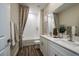 Bathroom featuring double vanity, framed mirrors, and shower with white textured tiles at 14427 Meadow Bird Ave, Riverview, FL 33579