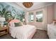 Stylish bedroom features pink accents, botanical wallpaper, and lots of natural light at 14427 Meadow Bird Ave, Riverview, FL 33579