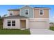 Two-story home featuring neutral-colored siding, attached two-car garage, and well-manicured lawn at 14789 Summer Branch Dr, Lithia, FL 33547