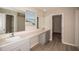 Bright bathroom featuring double sinks, quartz countertop, and a walk-in closet at 14811 Summer Branch Dr, Lithia, FL 33547