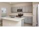 A modern kitchen with gray cabinets, stainless steel appliances, and a center island with a sink at 14811 Summer Branch Dr, Lithia, FL 33547