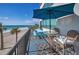 Relaxing outdoor balcony area with ocean views, table, chairs, and blue umbrella at 1600 Gulf Blvd # 212, Clearwater Beach, FL 33767