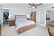 Bright bedroom with a wooden bed frame, ceiling fan, and access to a balcony with ocean views at 1600 Gulf Blvd # 212, Clearwater Beach, FL 33767