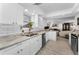 Modern kitchen featuring white cabinets, granite countertops, stainless steel appliances, open to living area at 1600 Gulf Blvd # 212, Clearwater Beach, FL 33767