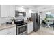 Bright kitchen with stainless steel appliances, granite countertops, and a view to the dinette at 1600 Gulf Blvd # 212, Clearwater Beach, FL 33767