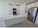 Modern kitchen boasts white cabinets, quartz countertops, and stainless steel appliances at 209 Lazy Shore Dr, Nokomis, FL 34275
