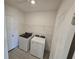 Well-lit laundry room complete with modern appliances and a wire shelf for storage at 209 Lazy Shore Dr, Nokomis, FL 34275
