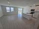 Open-concept living space with abundant natural light, tile flooring, and modern kitchen at 209 Lazy Shore Dr, Nokomis, FL 34275