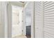 Hallway view looking into tiled full bathroom featuring tiled shower and tub combo at 2650 Countryside Blvd # B-110, Clearwater, FL 33761