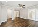 Spacious room with a ceiling fan, dark wood floors, crown molding, and closets and bathroom access at 2650 Countryside Blvd # B-110, Clearwater, FL 33761