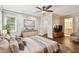 Bright bedroom featuring a ceiling fan, dark hardwood floors, and an ensuite bathroom with modern vanity at 2650 Countryside Blvd # B-110, Clearwater, FL 33761