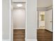 Shot of a closet with a light; view into a bathroom, showing white walls and wood floor at 2650 Countryside Blvd # B-110, Clearwater, FL 33761